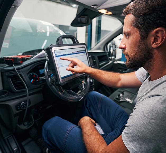 certified auto body repair technician scanning vehicle sensors